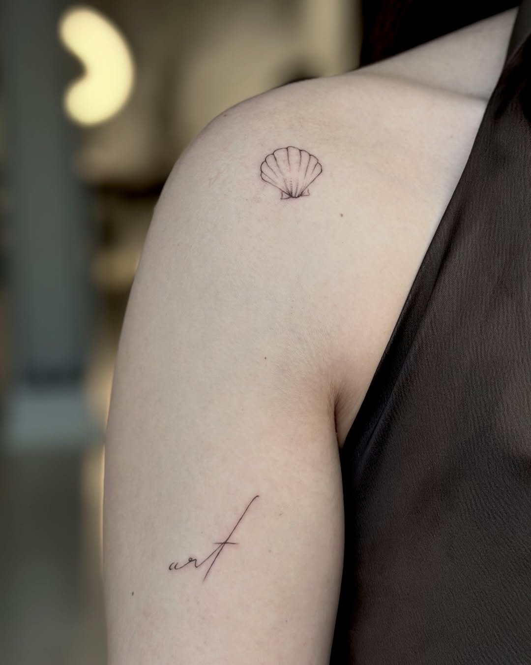 Omuz deniz kabuğu ve art yazısı dövmesi — minimal ince çizgi ikili | Titan Ink Gallery Samsun